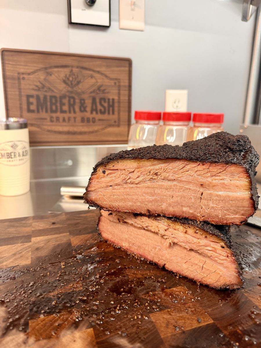 Two thick slices of smoked brisket stacked on a cutting board